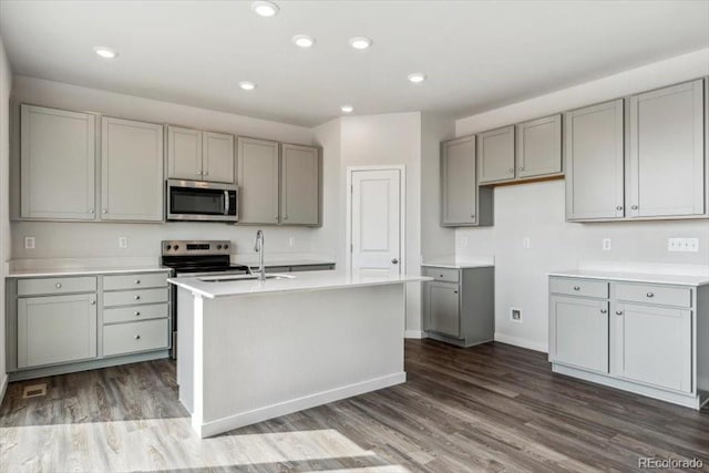 14378 Heritage Dr, Mead, CO 80504 - kitchen with stainless steel appliances, gray cabinetry, a sink, and dark wood finished floors