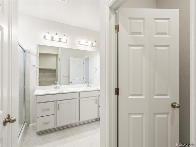 bathroom featuring tile patterned floors, vanity, and a shower with shower door