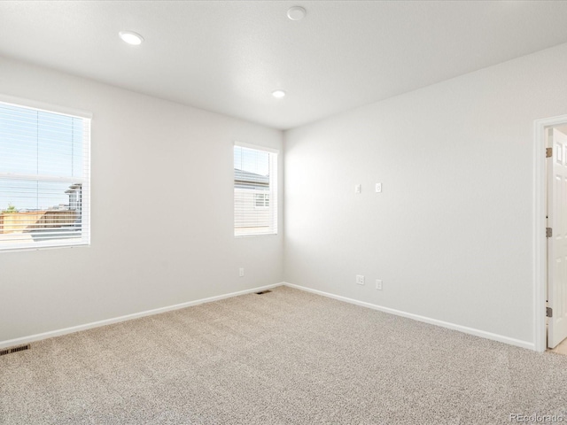 unfurnished room with light carpet, baseboards, visible vents, and recessed lighting