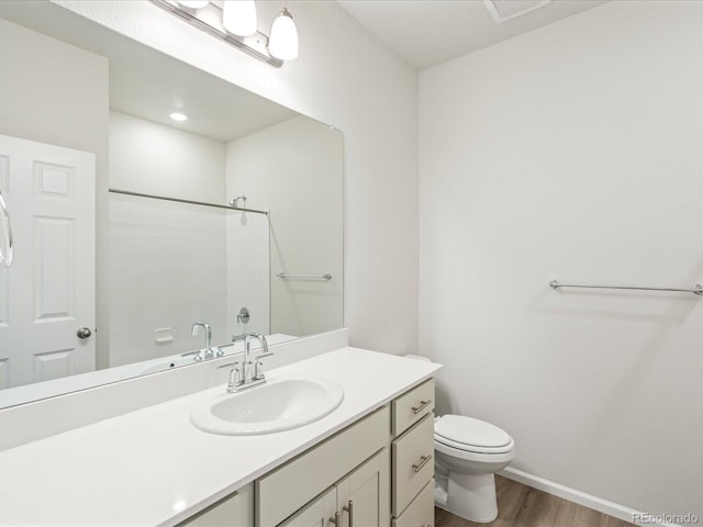 bathroom featuring vanity, wood finished floors, toilet, and baseboards