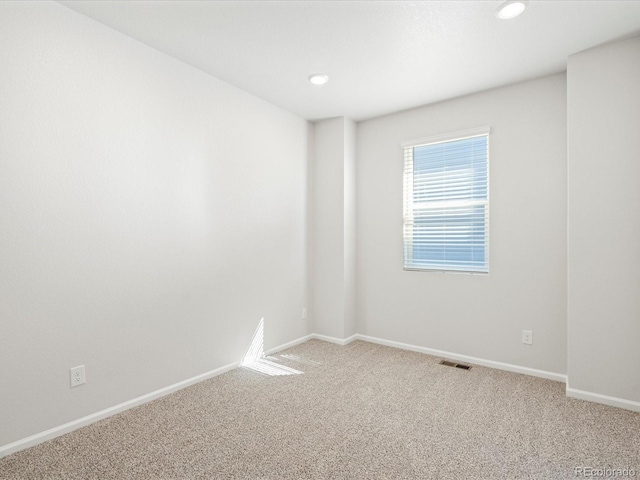 unfurnished room with carpet, visible vents, baseboards, and recessed lighting