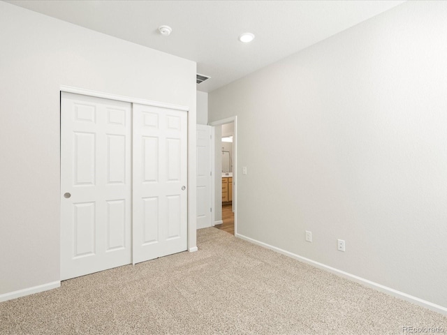 unfurnished bedroom with a closet, carpet flooring, visible vents, and baseboards