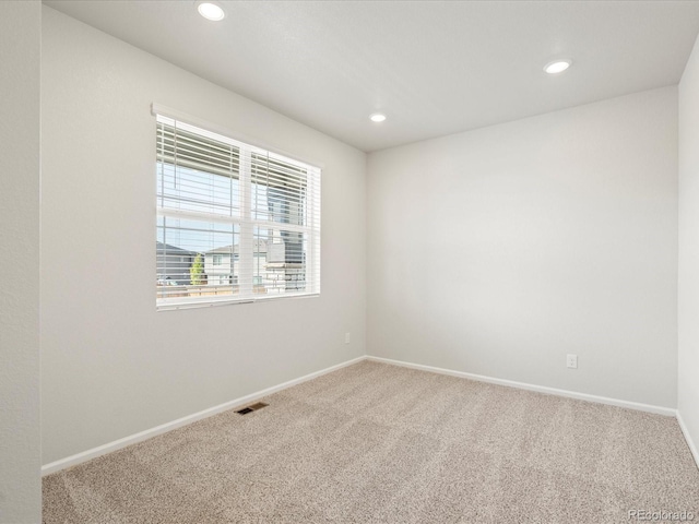 carpeted empty room featuring recessed lighting, visible vents, and baseboards