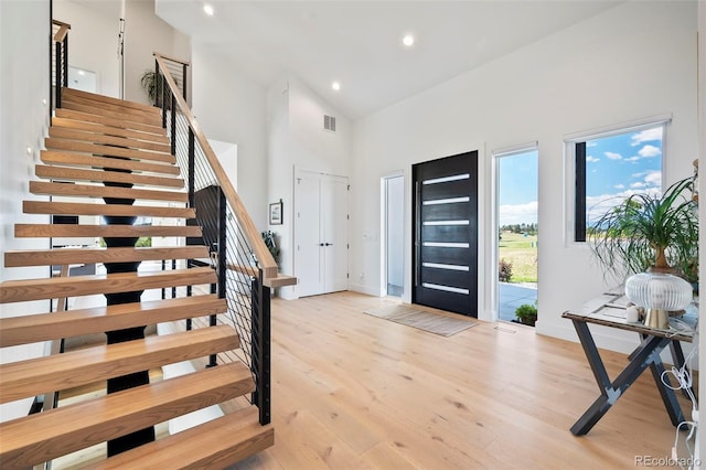 entrance foyer featuring high vaulted ceiling and light hardwood / wood-style floors