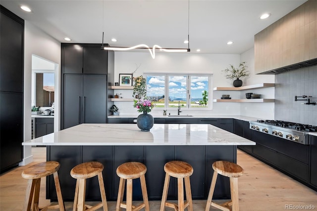 kitchen with light stone countertops, sink, and a kitchen breakfast bar