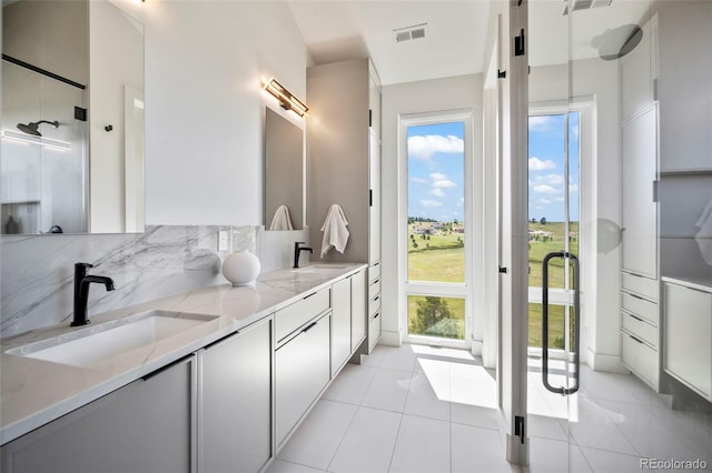 bathroom featuring vanity, decorative backsplash, and tile patterned floors