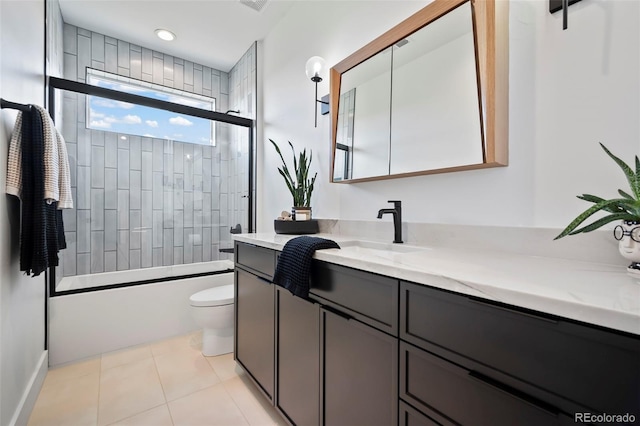 full bathroom with tile patterned flooring, vanity, combined bath / shower with glass door, and toilet