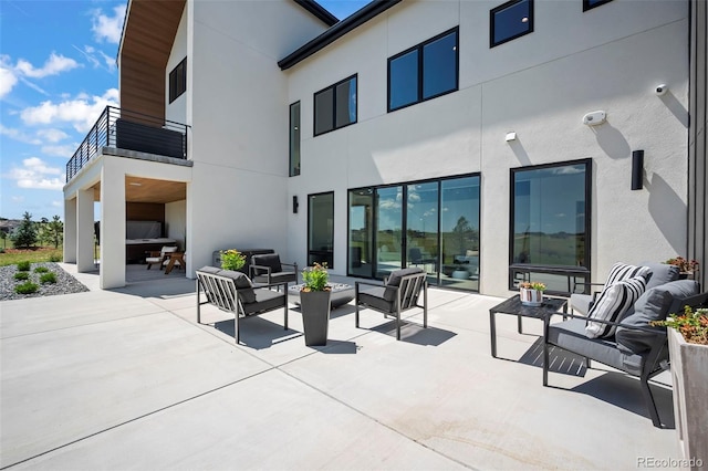 back of house featuring an outdoor living space, a patio, and a balcony