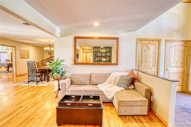 living room with an inviting chandelier and light hardwood / wood-style flooring