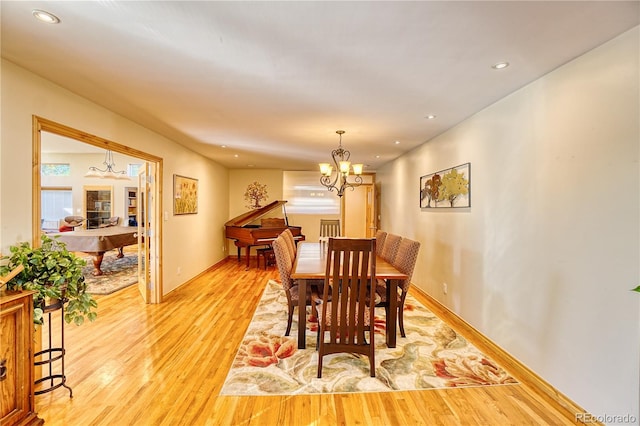 dining area featuring light wood-type flooring and a chandelier