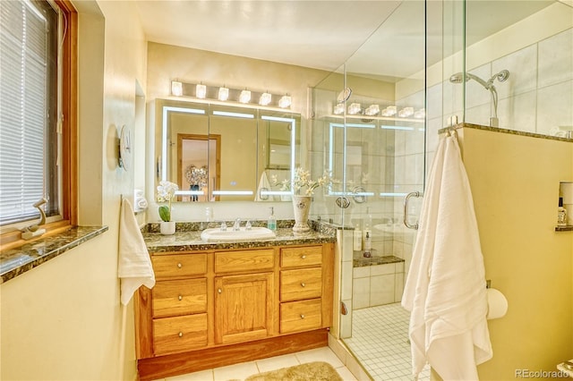 bathroom with tile patterned flooring, vanity, and a shower with door