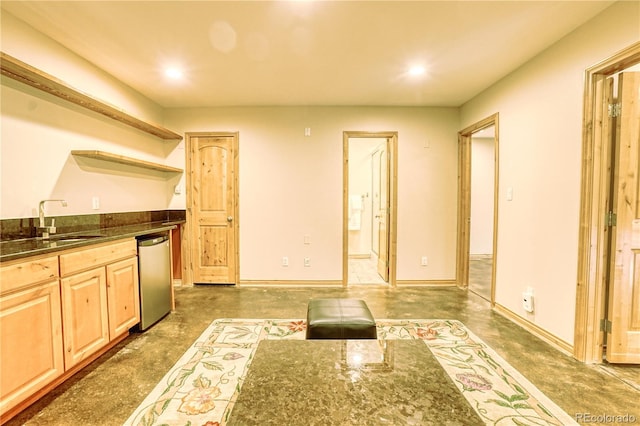 kitchen with dishwasher, light brown cabinets, and sink