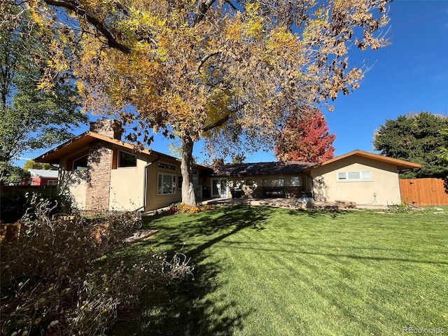 rear view of property with a lawn