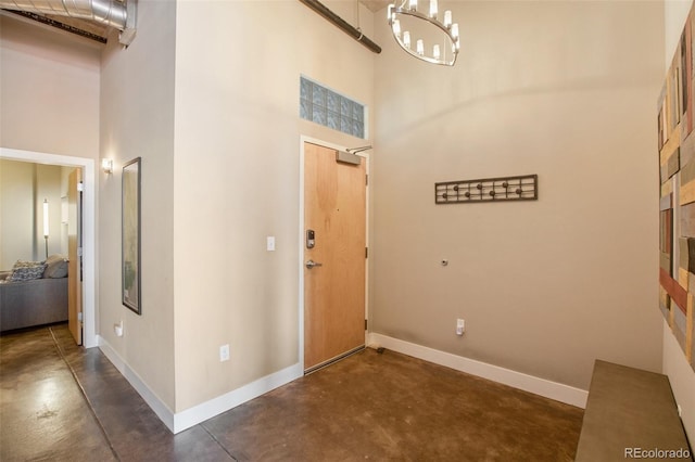 entrance foyer featuring a towering ceiling and an inviting chandelier