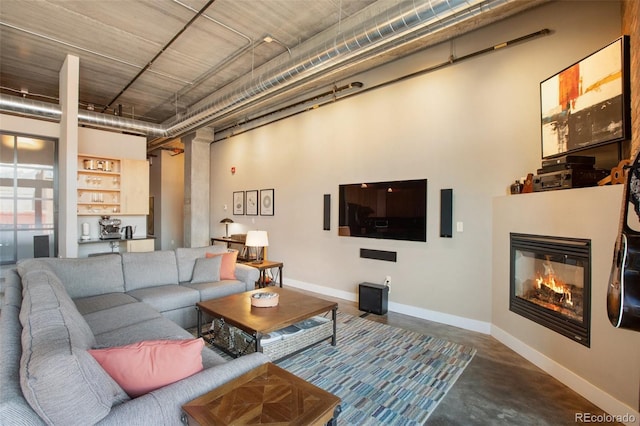 living room featuring a high ceiling and concrete floors