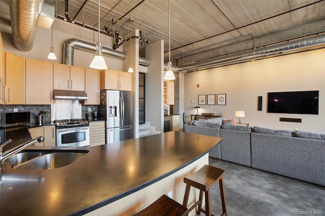 kitchen featuring sink, light brown cabinets, decorative light fixtures, decorative backsplash, and appliances with stainless steel finishes