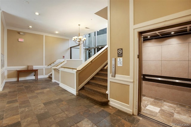 stairway with ornamental molding and a notable chandelier