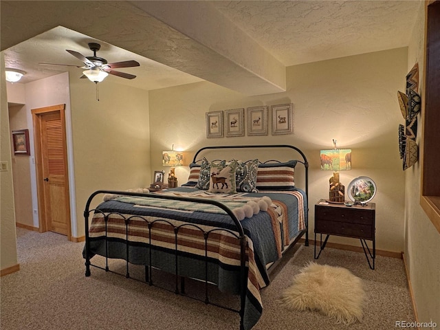 bedroom with carpet, a textured ceiling, and ceiling fan