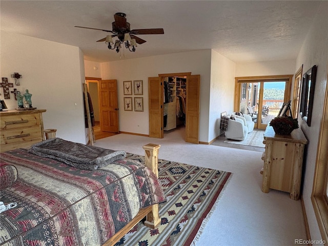 carpeted bedroom featuring ceiling fan, a walk in closet, and a closet