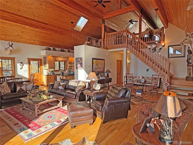 living room with a skylight, ceiling fan, high vaulted ceiling, wooden ceiling, and beamed ceiling