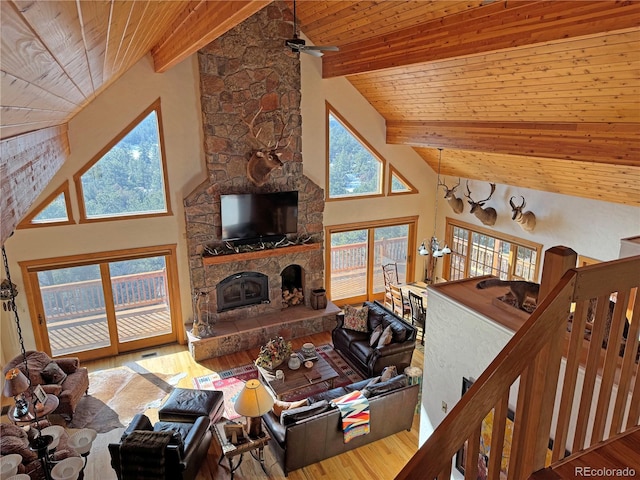 living room featuring beamed ceiling, wooden ceiling, and a fireplace