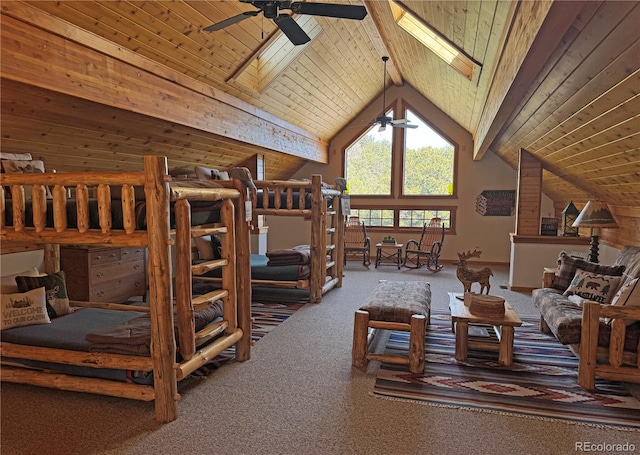 interior space featuring lofted ceiling with skylight, carpet floors, wood ceiling, and ceiling fan