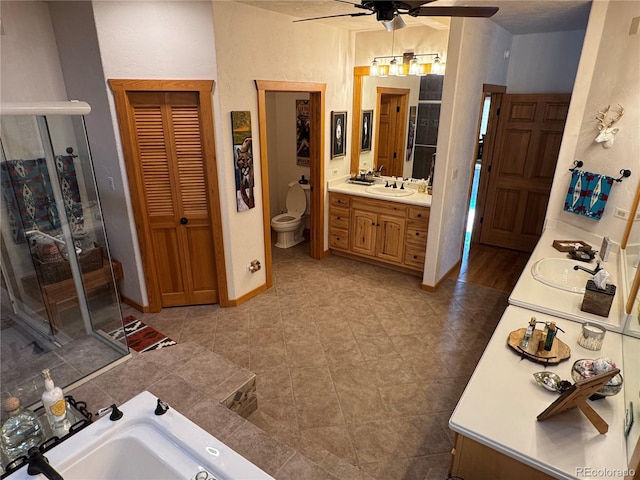 bathroom with tile patterned floors, vanity, ceiling fan, toilet, and a tub