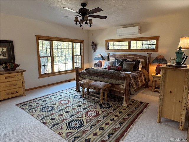 carpeted bedroom featuring ceiling fan and a wall mounted air conditioner