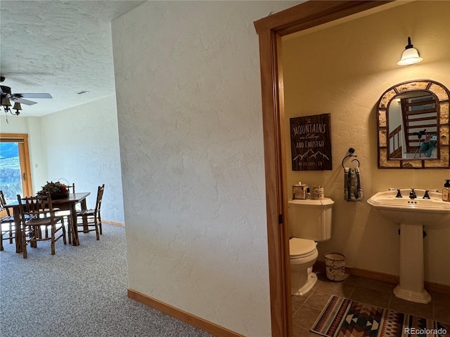 bathroom featuring a textured ceiling, toilet, and ceiling fan