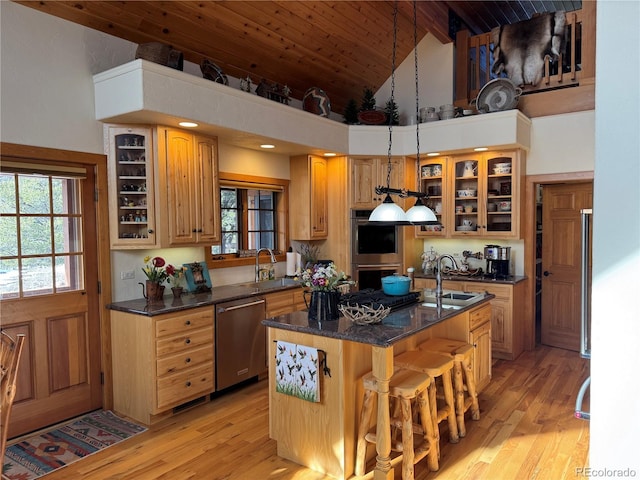 kitchen featuring a center island, high vaulted ceiling, hanging light fixtures, appliances with stainless steel finishes, and a breakfast bar area