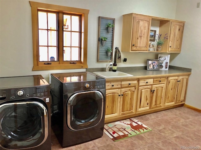 laundry room featuring light tile patterned flooring, cabinets, sink, and washing machine and clothes dryer