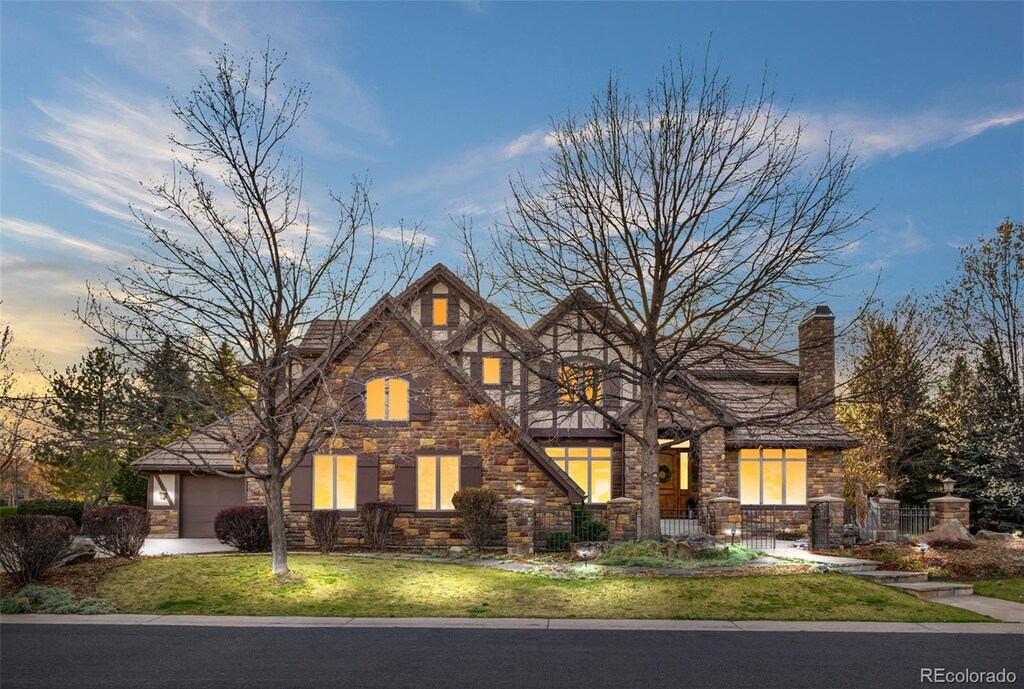 35 Brookhaven Ln, Littleton, CO 80123 - english style home with an attached garage, fence, stone siding, and a front lawn