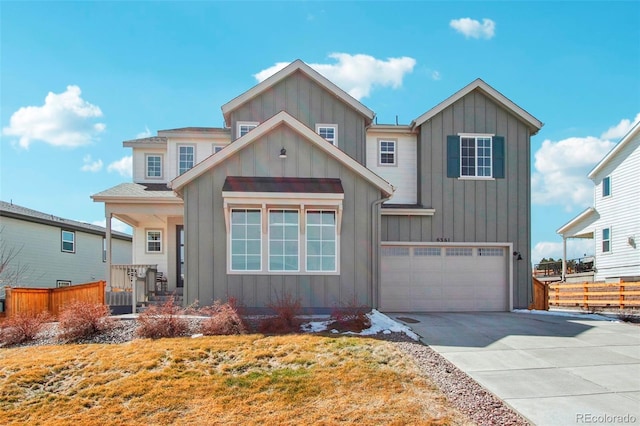 view of front of house with concrete driveway, an attached garage, fence, and board and batten siding