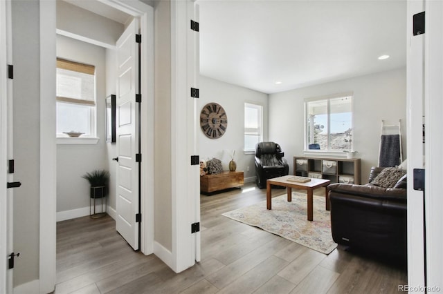 living area with recessed lighting, wood finished floors, and baseboards