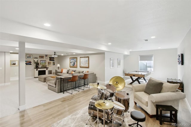 living room featuring recessed lighting, baseboards, and light wood finished floors