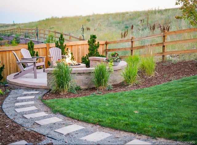 view of yard with a fire pit and fence