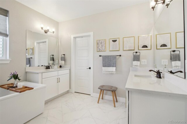 bathroom with a sink, baseboards, two vanities, and marble finish floor