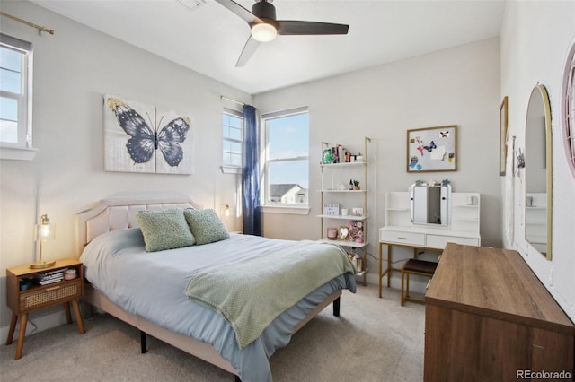 carpeted bedroom with visible vents, multiple windows, and a ceiling fan