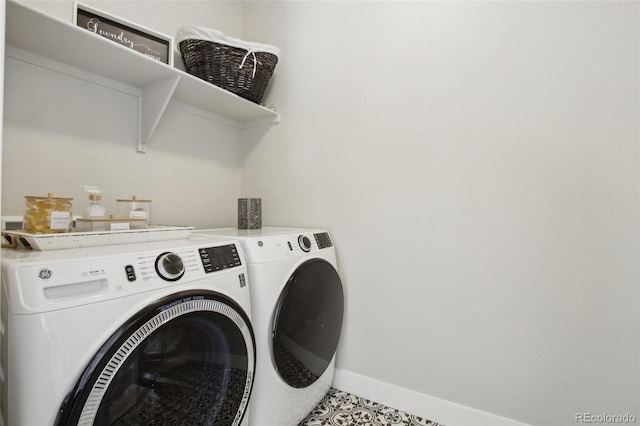 washroom with baseboards, washing machine and dryer, and laundry area