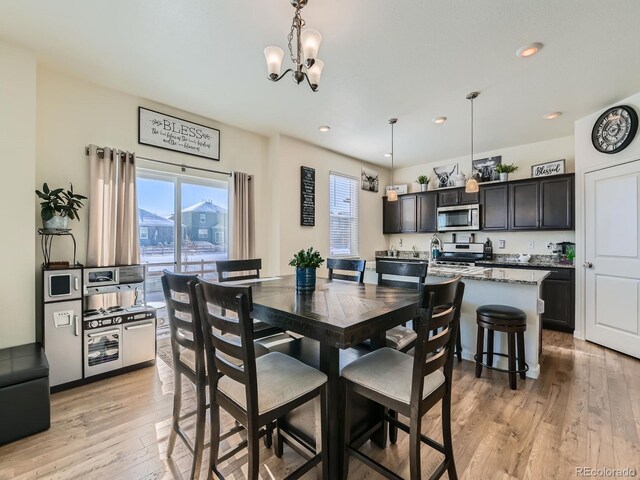 dining area with a notable chandelier and light hardwood / wood-style flooring