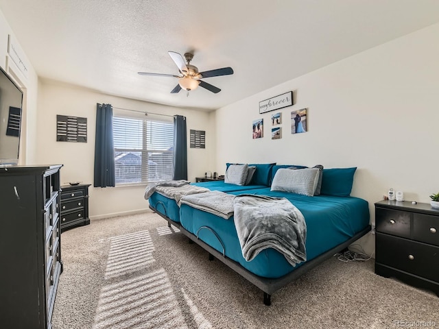 carpeted bedroom with ceiling fan and a textured ceiling