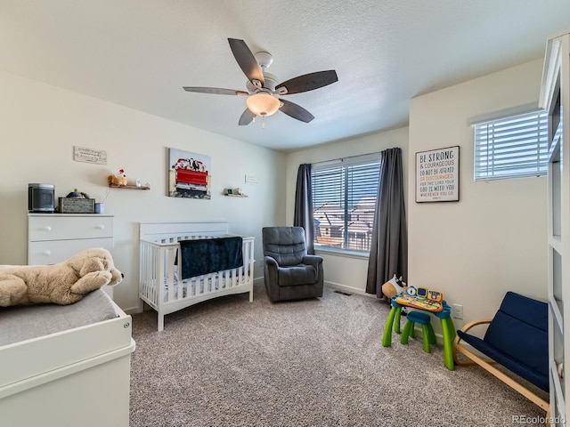 bedroom featuring carpet flooring, ceiling fan, and a crib