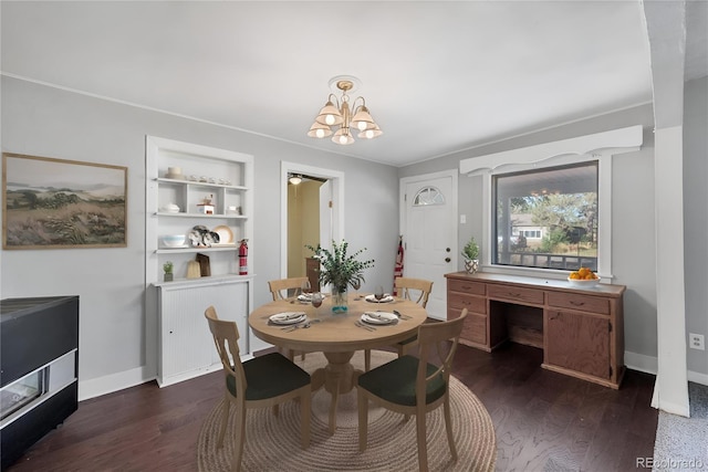 dining room with built in features, dark hardwood / wood-style floors, and a chandelier