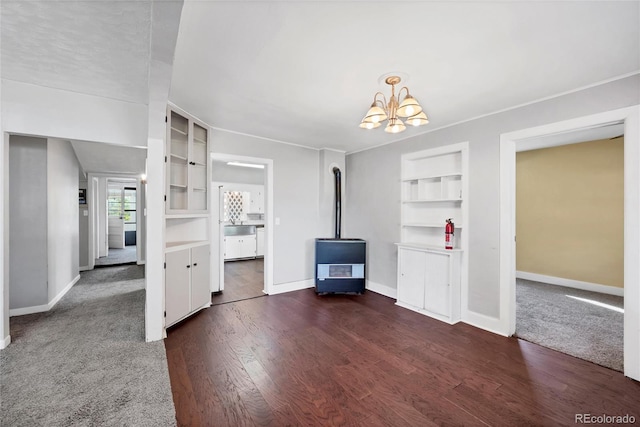 unfurnished living room featuring dark wood-type flooring, an inviting chandelier, and built in shelves