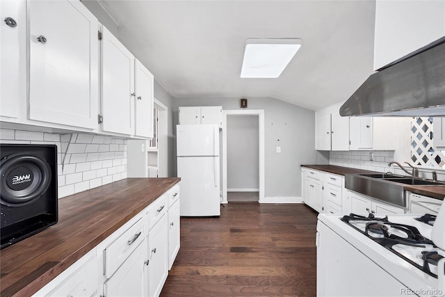 kitchen featuring lofted ceiling, sink, white appliances, wooden counters, and white cabinetry