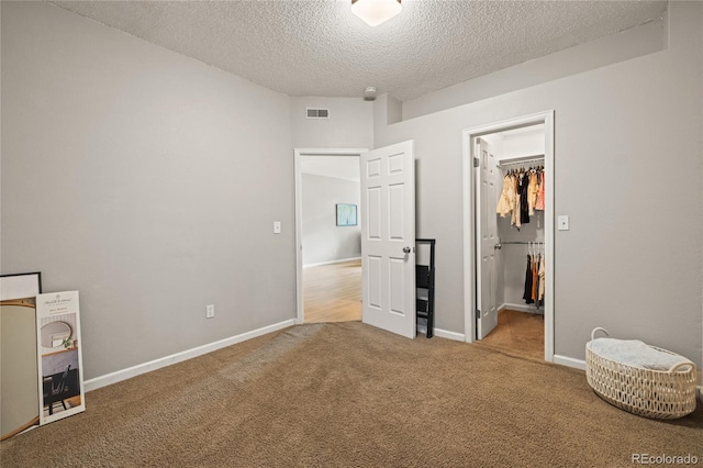 7452 Singing Hills Dr, Boulder, CO 80301 - unfurnished bedroom featuring a textured ceiling, carpet, a walk in closet, baseboards, and a closet