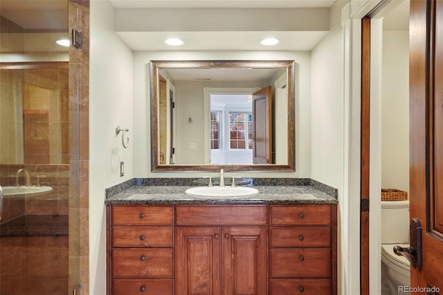 full bathroom featuring a shower stall, toilet, and vanity