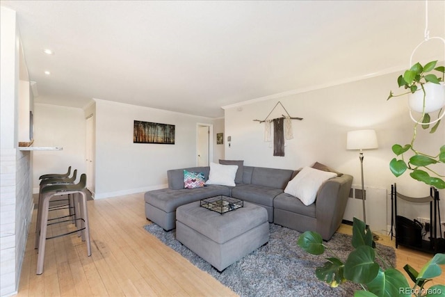 living room featuring baseboards, ornamental molding, recessed lighting, and light wood-style flooring