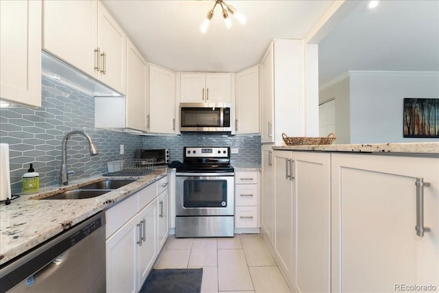 kitchen with a sink, white cabinetry, backsplash, and stainless steel appliances