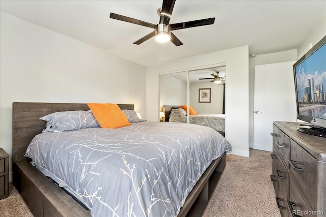 bedroom with a ceiling fan, light carpet, and a closet